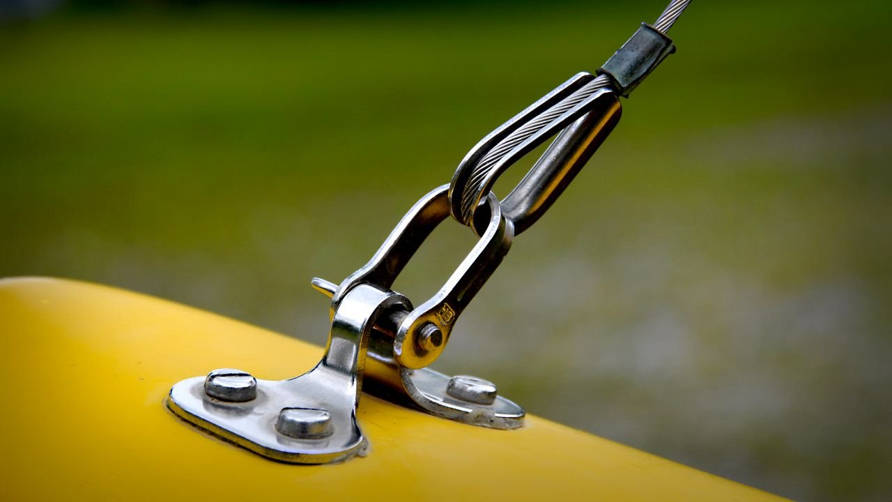 Close-up of stainless steel rigging and yellow surface, emphasizing durability.